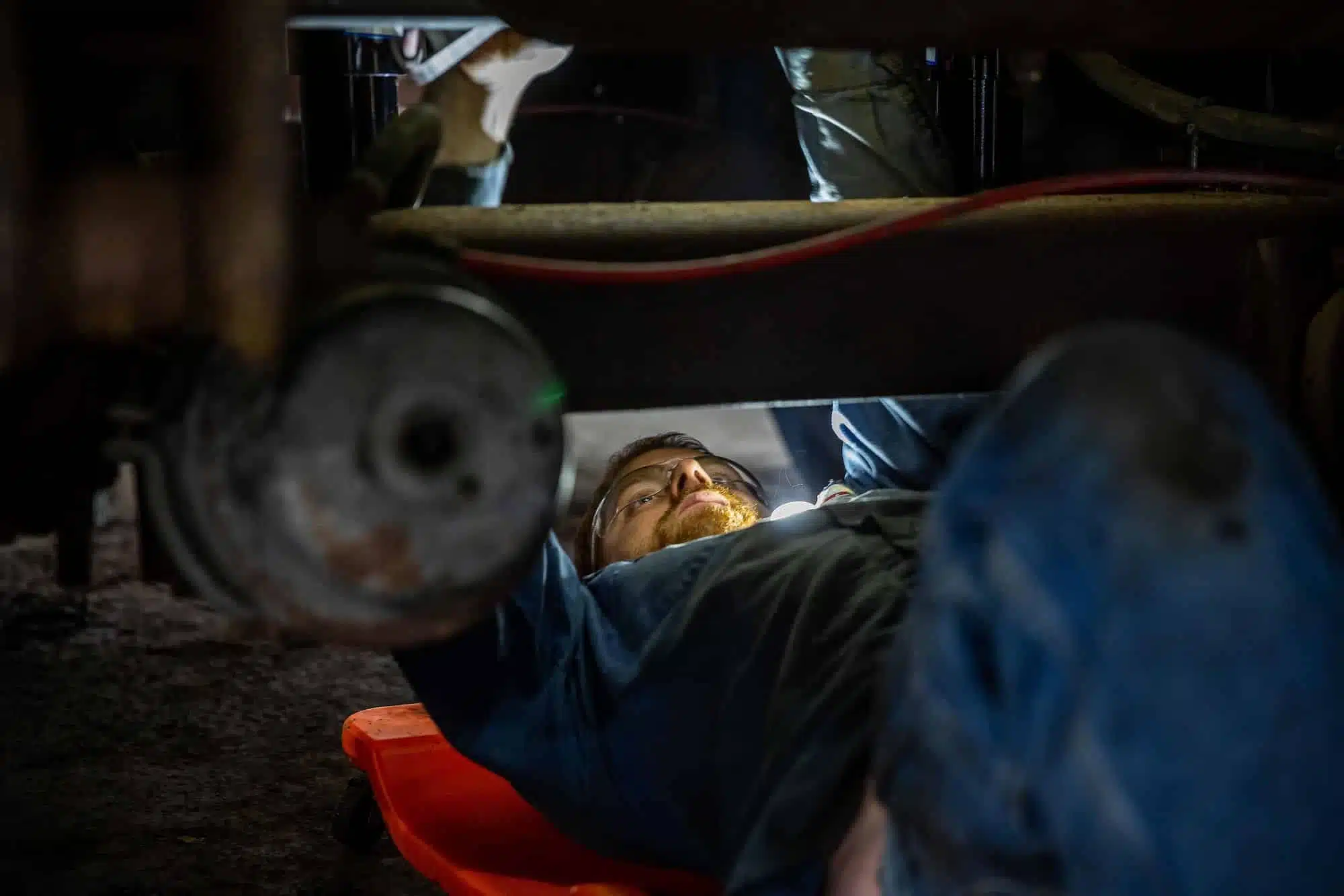 Man on creeper working under vehicle